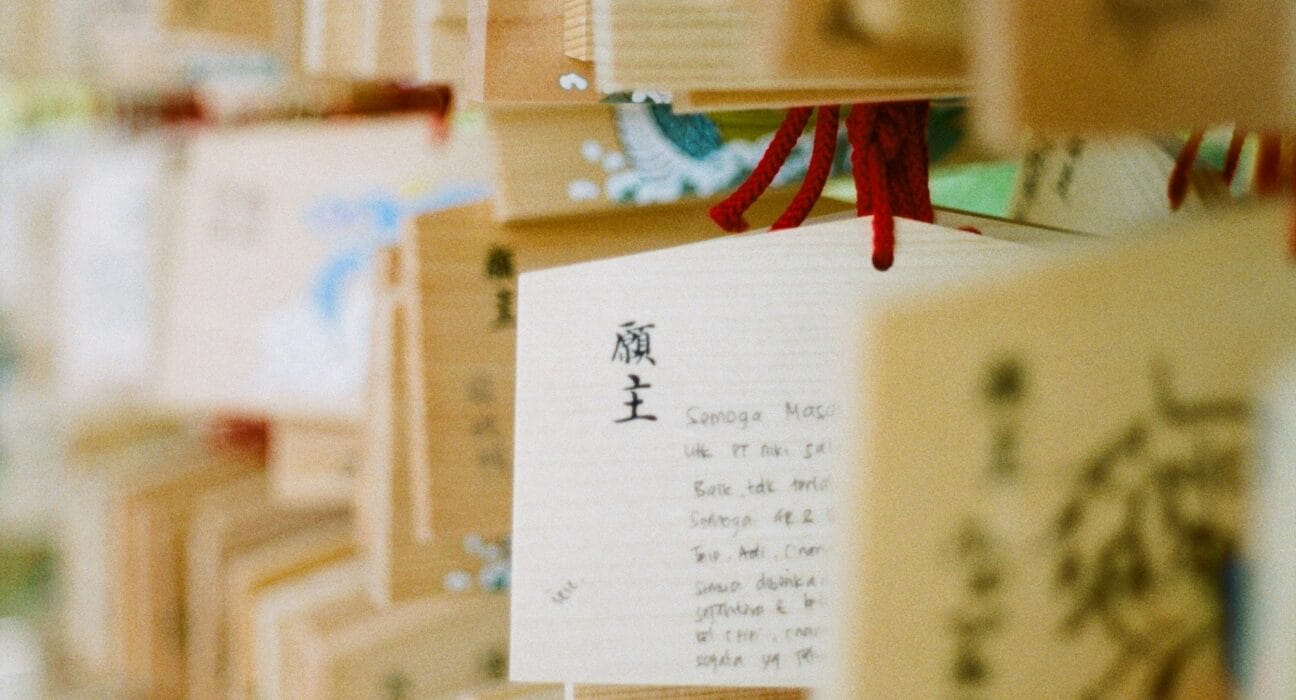 Omamori Sumber gambar: https://unsplash.com/photos/a-bunch-of-wooden-boxes-with-writing-on-them-5XGVY-MHE4I
