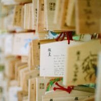 Omamori Sumber gambar: https://unsplash.com/photos/a-bunch-of-wooden-boxes-with-writing-on-them-5XGVY-MHE4I