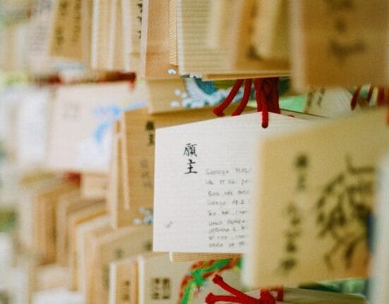 Omamori Sumber gambar: https://unsplash.com/photos/a-bunch-of-wooden-boxes-with-writing-on-them-5XGVY-MHE4I