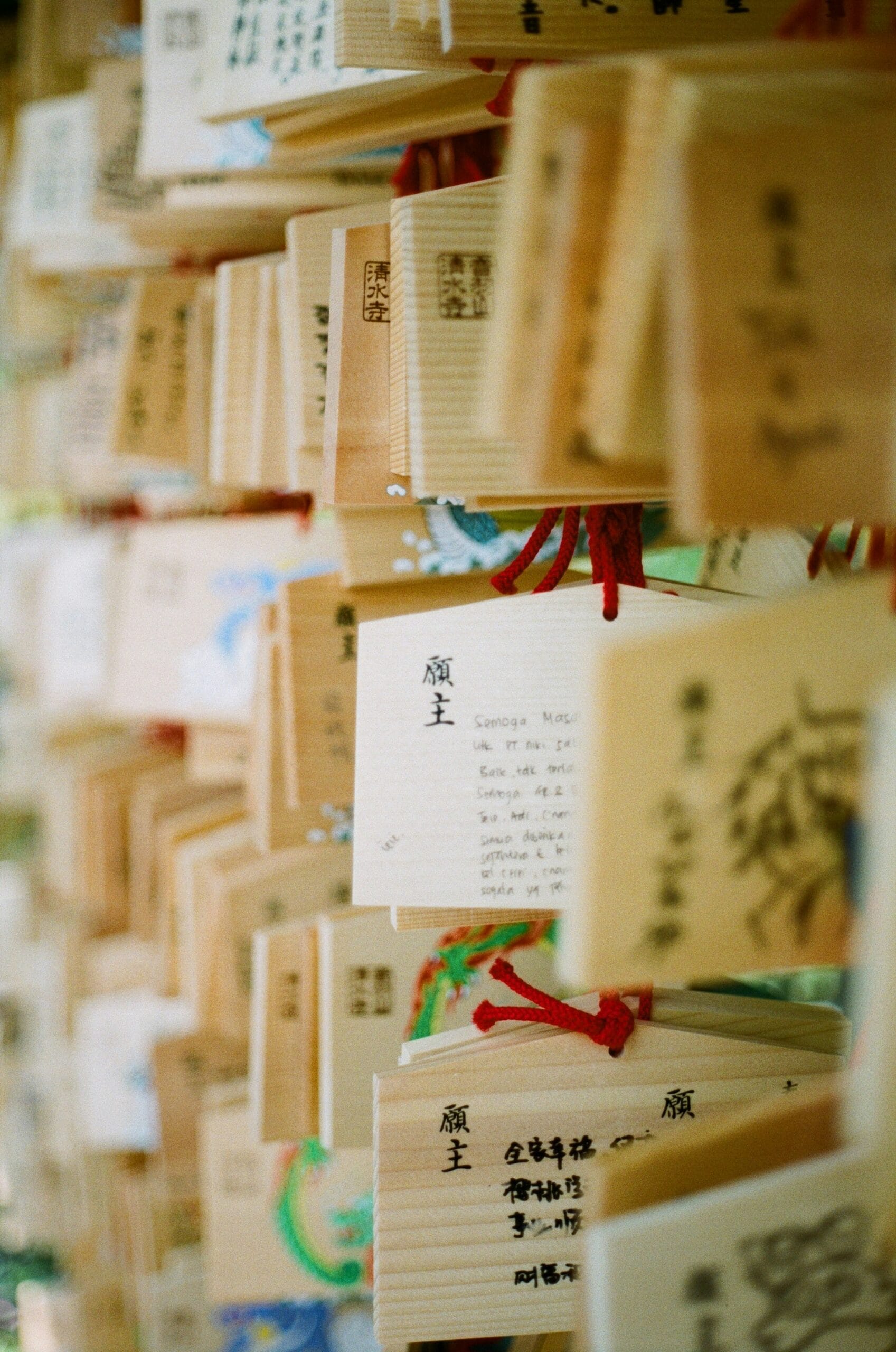 Omamori Sumber gambar: https://unsplash.com/photos/a-bunch-of-wooden-boxes-with-writing-on-them-5XGVY-MHE4I